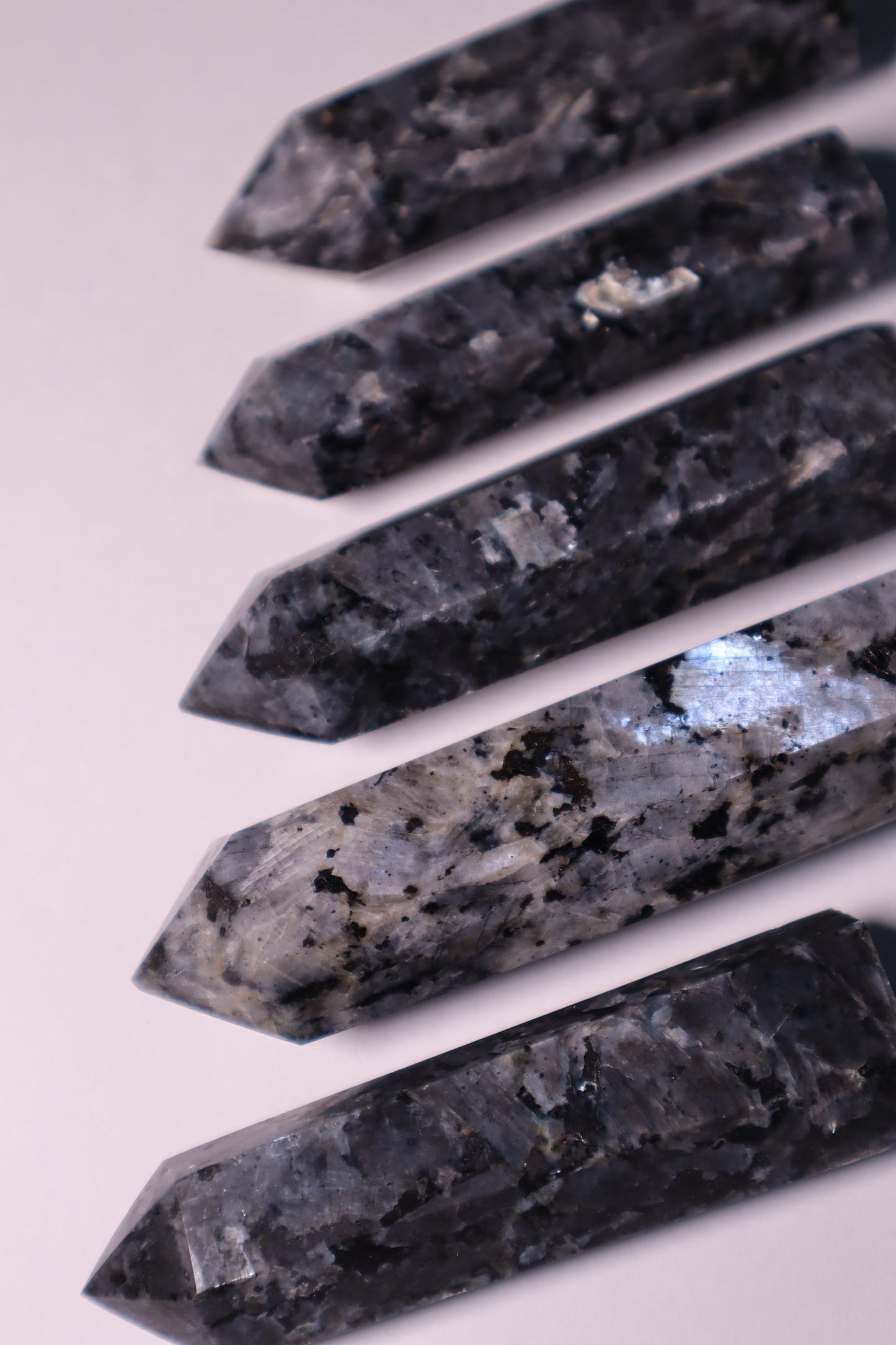Larvikite: An enigmatic and visually captivating crystal, is cherished for its deep gray-black color adorned with mesmerizing flashes of iridescent blue and silver.